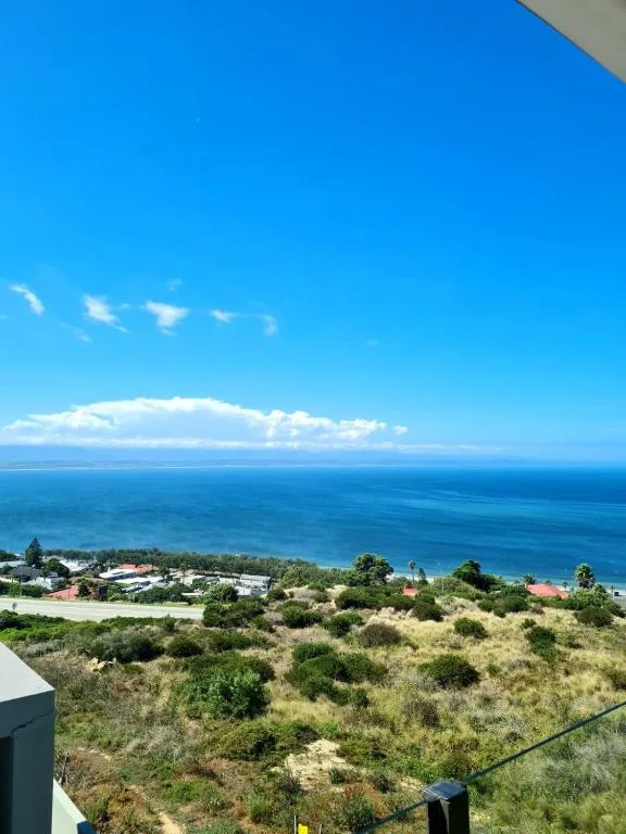 Expansive ocean view with coastal town nestled below clear blue sky