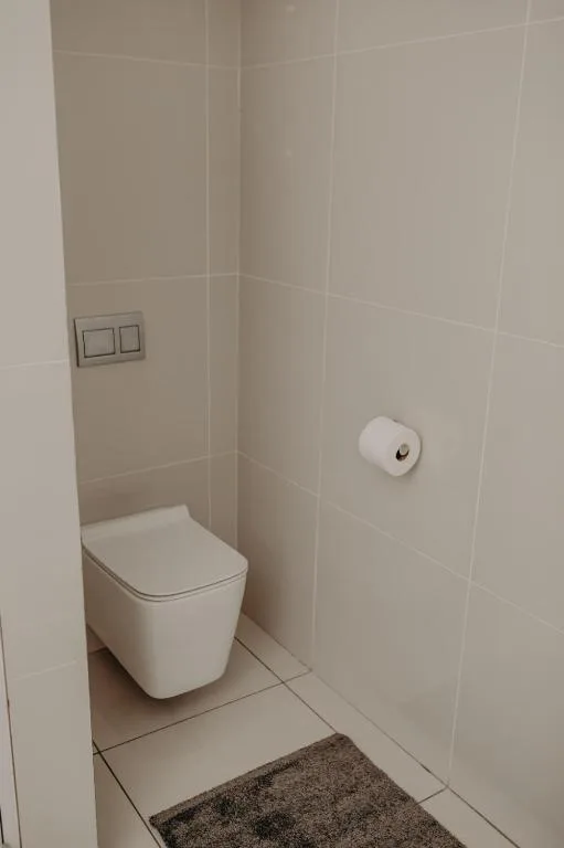 Clean modern bathroom with wall-mounted toilet and tiled walls