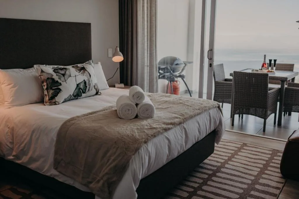Spacious bedroom with ocean view, modern furnishings, and coastal decor