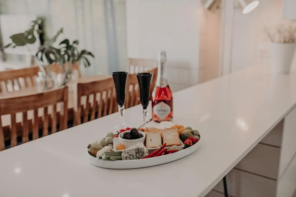 Elegant dining table with champagne, charcuterie board, and wooden chairs
