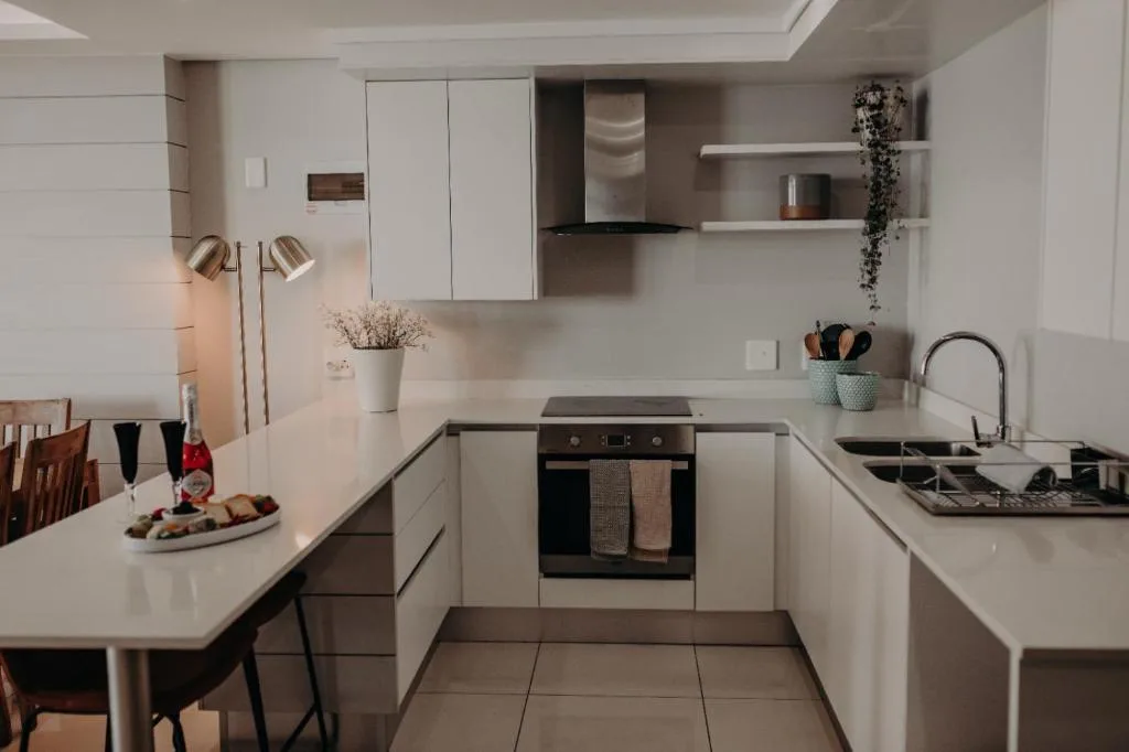 Modern white kitchen with stainless steel appliances and clean countertops