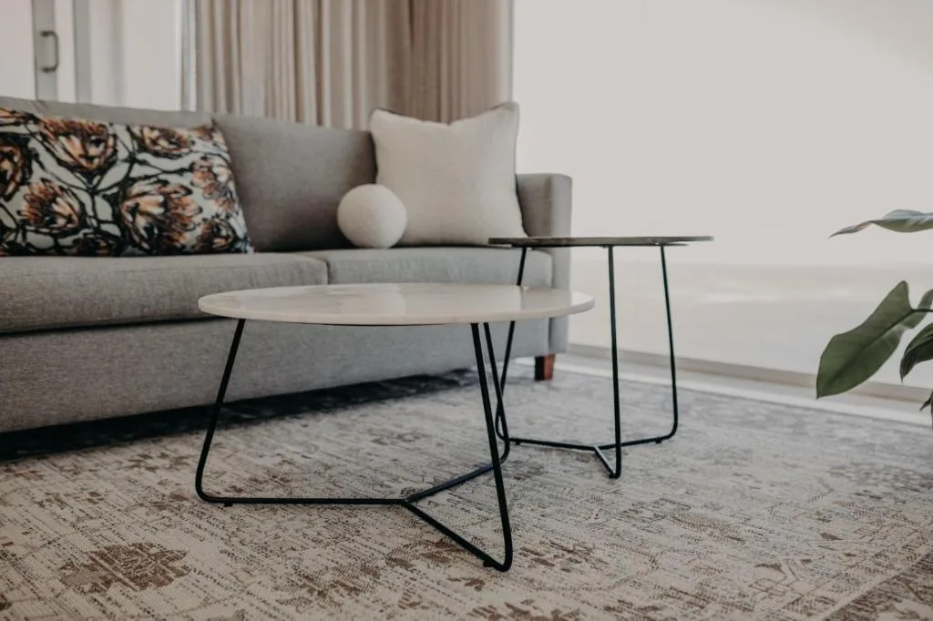 Modern gray sofa with patterned cushions and minimalist coffee tables