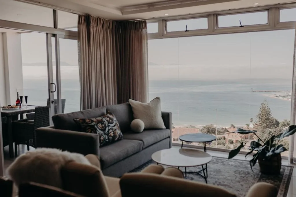 Panoramic ocean and coastal town views from modern lounge with floor-to-ceiling windows