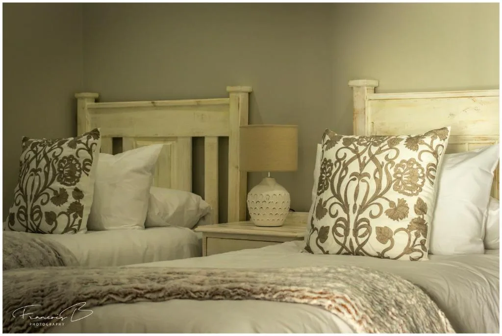Twin beds with decorative pillows and cream wooden headboards