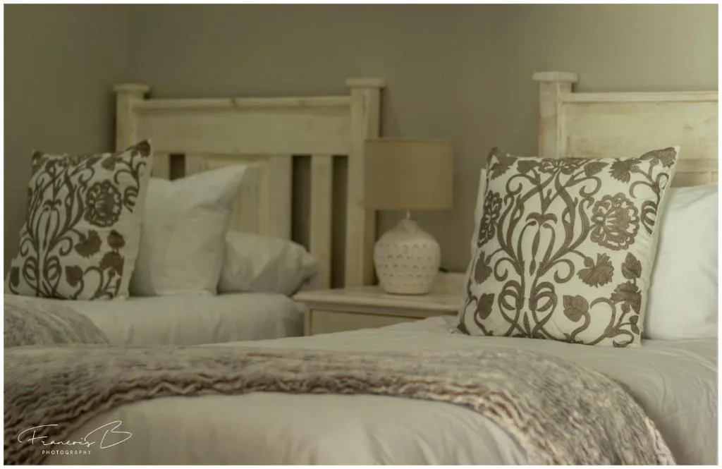 Elegantly styled bed with decorative pillows and neutral bedding in calm bedroom