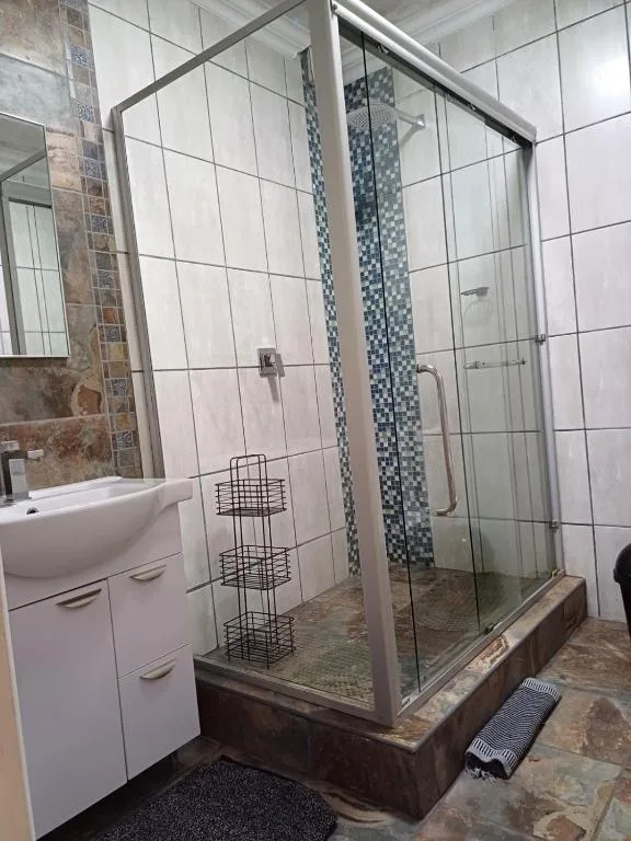 Modern bathroom with enclosed shower cubicle and white vanity sink