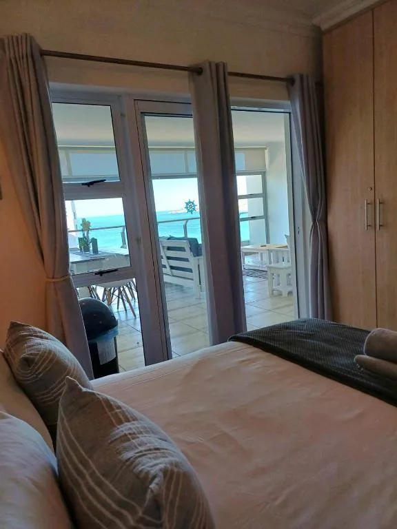 Bedroom with double bed and ocean view through sliding glass doors