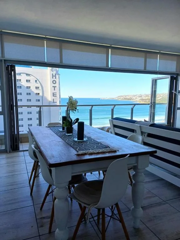 Stunning ocean and coastal views from modern dining area with table and chairs