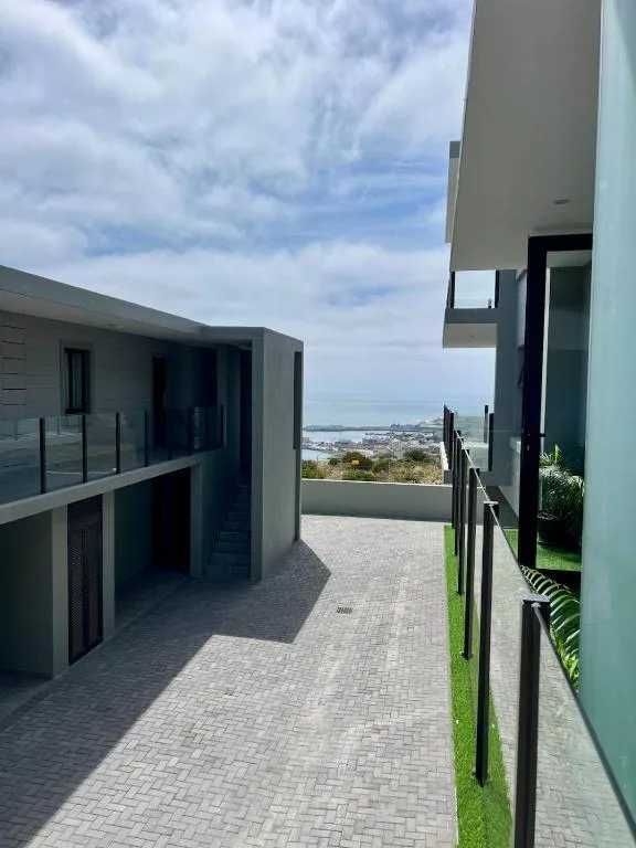 Modern paved terrace with coastal town view and contemporary architecture
